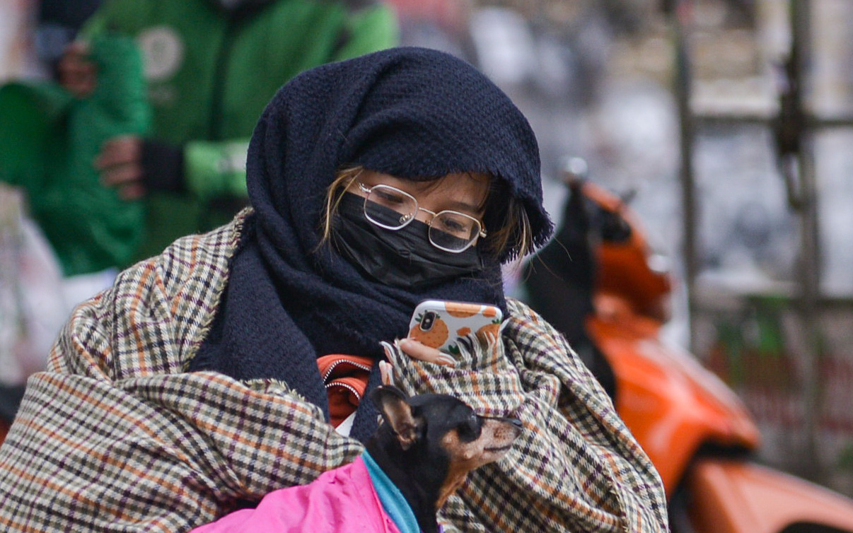 Hà Nội: Nhiệt độ xuống 12 độ C, người dân mặc áo mưa ra đường và đốt lửa sưởi ấm
