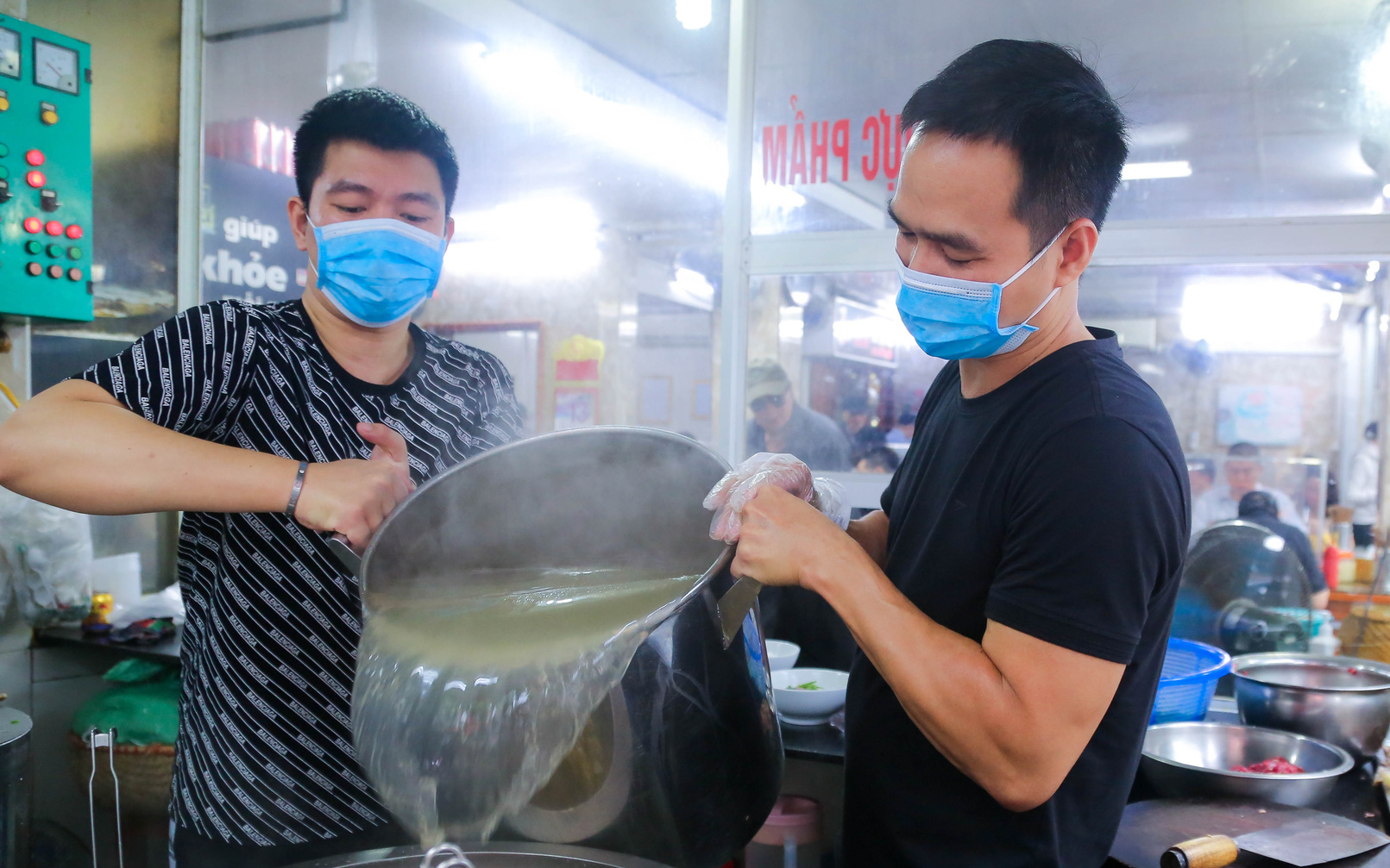 Ảnh ấn tượng tuần: Người Đà Nẵng mặc áo mưa ăn sáng và quán phở bán 1.000 bát trong ngày