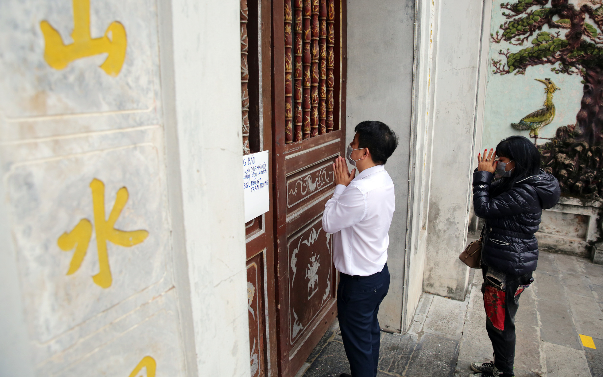 Đền chùa tại Hà Nội đóng cửa, người dân vái vọng qua khung cửa cầu may mắn và tài lộc